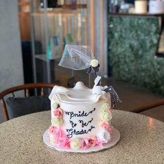 White cake with bride silhouette, veil and flowers, by DOT Cake Art