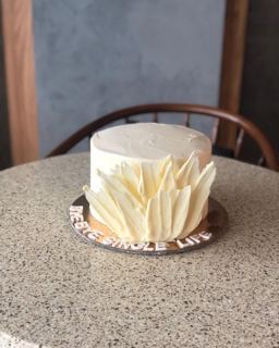 White cake with tall white chocolate feathers, by DOT Cake Art