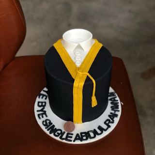 كيكة بشكل بشت أسود بحواف ذهبية وياقة ثوب لتوديع العزوبية من دوت كيك آرت