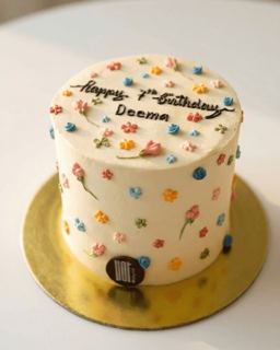 White cake with small colourful flowers, by DOT Cake Art