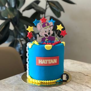 Blue Chuck E. Cheese cake with colorful stars, by DOT Cake Art