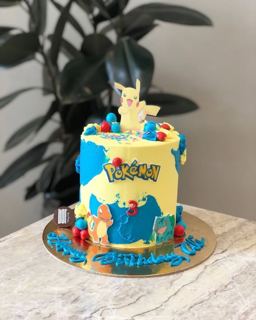 Yellow and blue Pokémon cake with Pikachu and Pokéballs, by DOT Cake Art