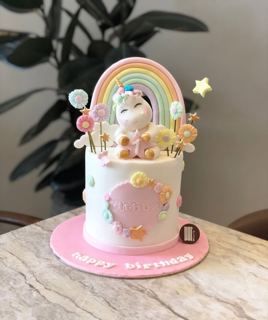 White unicorn cake with rainbow and lollipops, by DOT Cake Art