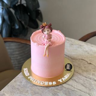 Pink cake with a little seated princess topper, by DOT Cake Art