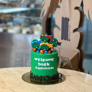 Green Ninja Turtles cake with welcome back message, by DOT Cake Art