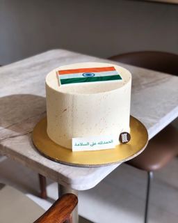 White cake with Indian flag and welcome-back message, by DOT Cake Art