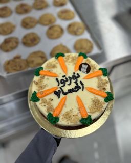 Carrot cake with carrot toppers and Arabic message, by DOT Cake Art