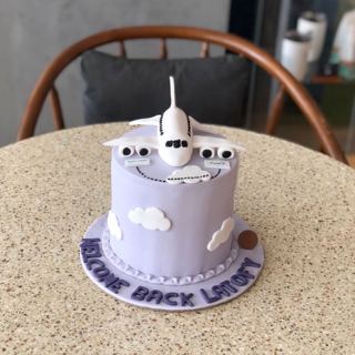 Lilac cake with plane and clouds, welcome back, by DOT Cake Art