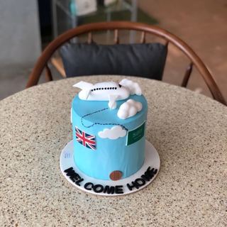 Blue cake with plane and flags, welcome home, by DOT Cake Art