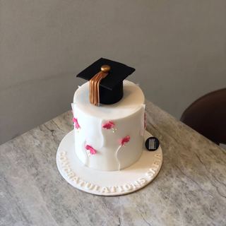 White cake with pink butterflies and grad cap, by DOT Cake Art