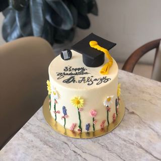 White cake with colourful flowers and grad cap, by DOT Cake Art