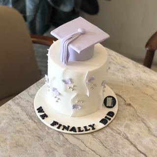 White cake with lilac graduation cap and butterflies, by DOT Cake Art