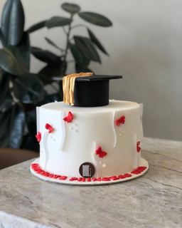 White cake with red butterflies and grad cap, by DOT Cake Art
