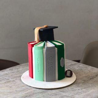 Colourful book-stack cake with graduation cap, by DOT Cake Art