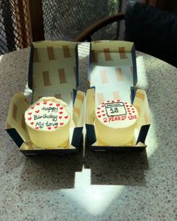 Two small white cakes with red hearts and calendar, by DOT Cake Art