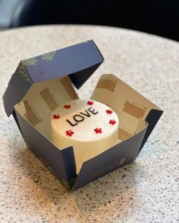 Small white cake with LOVE lettering and red hearts, by DOT Cake Art
