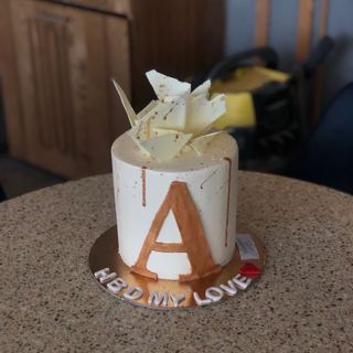 White cake with gold initial and white chocolate shards, by DOT Cake Art