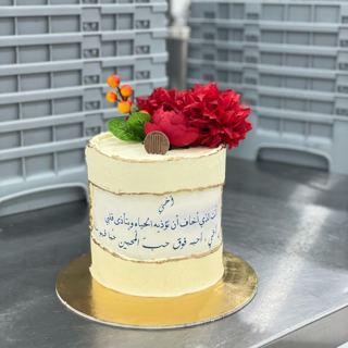 كيكة كريمية بحواف ذهبية وورد أحمر وتوت برتقالي وخط عربي مطبوع من دوت كيك آرت