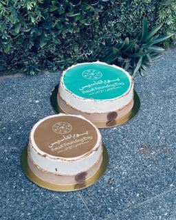 Two cakes in green and brown with Founding Day logo, by DOT Cake Art