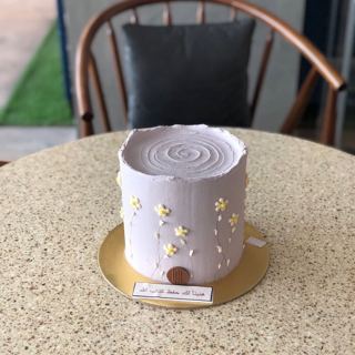 Light lilac cake with tiny yellow flowers, by DOT Cake Art