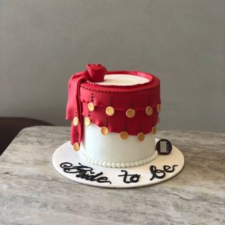 White cake with red drape and gold coins, by DOT Cake Art