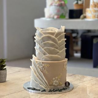 Two-tier beige cake with petals and flowers, by DOT Cake Art