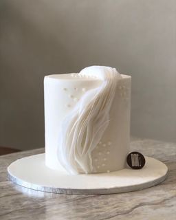 White cake with bridal veil and pearls, by DOT Cake Art